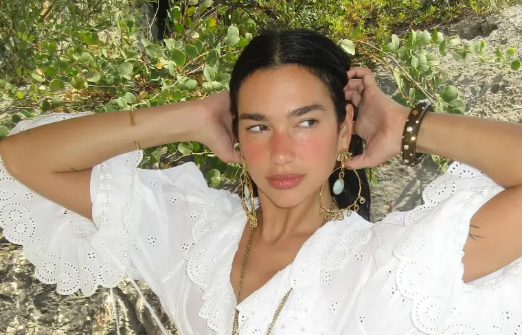 Dua Lipa showed off her incredibly trim body in a stunning white see-through top as she enjoys the sunshine