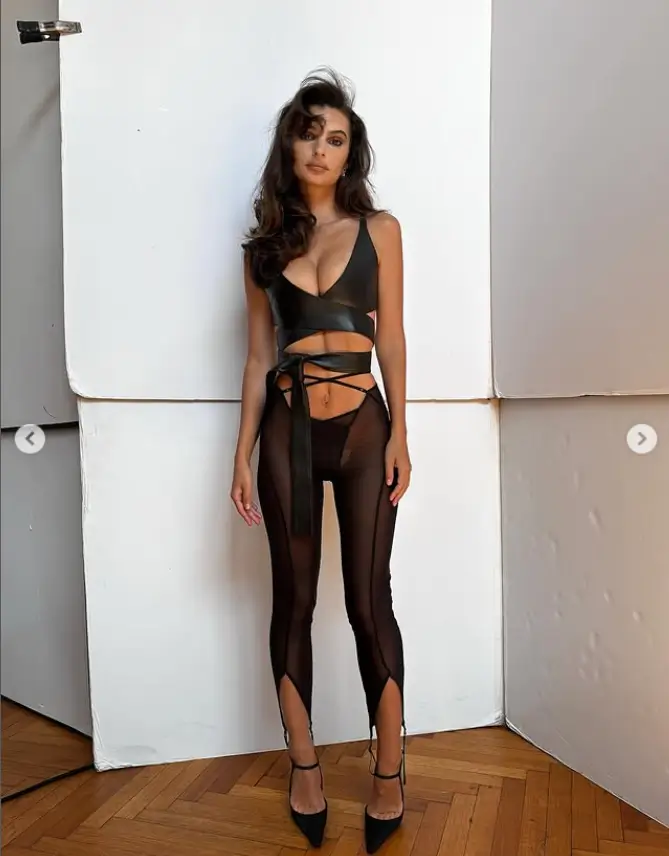 The supermodel chose a vinyl-come-leather look and posed by a white wall, showing off her curves and making her eyes pop with her ample cleavage in a racy, criss-cross bralette with a plunging neckline.