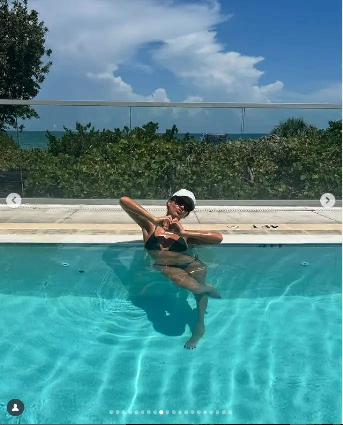 Her collection also included snapshots of her leisure time by the pool. One particular photo stood out, capturing her in a minuscule, black bikini. She posed elegantly in a rooftop pool, embodying a sense of freedom and joy.