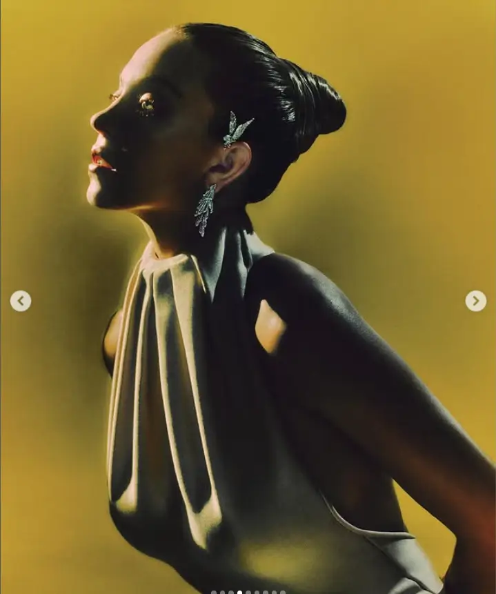 In a subsequent pose, Sydney demonstrated a ballerina-inspired stretch in her black dress, further accentuating her curves in a backless, braless ensemble with a gold G-string.