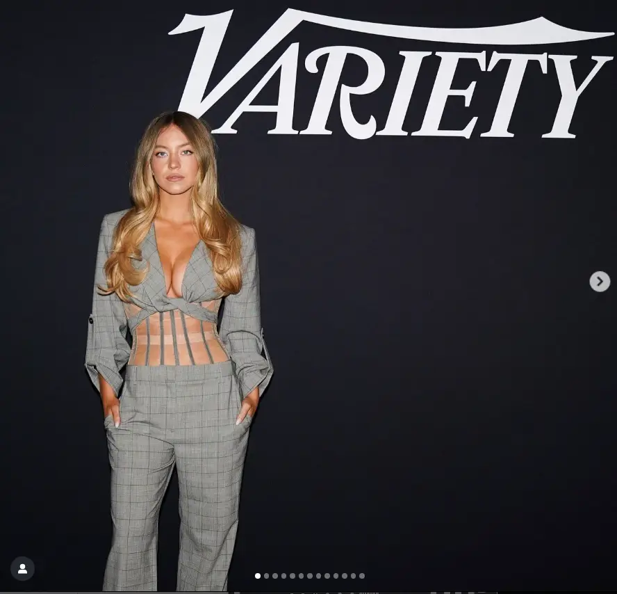 Sydney Sweeney showed off her cleavage by wearing a gray cropped jacket with a deep plunging neckline in front.
